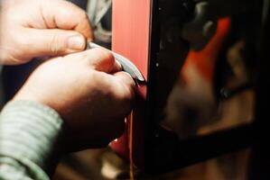 locksmith hands sharpen the workpiece for a knife photo