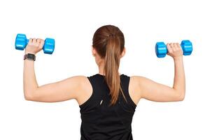 woman performs an exercise with dumbbells, view from the back on a white background photo