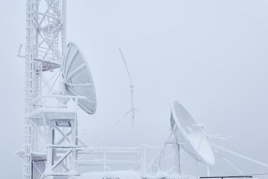 frosty parabolic antennas and the basement of the cell tower on the base radio station located in the highlands photo