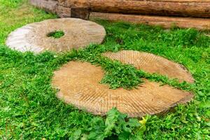 old shattered millstone lies on the grass photo