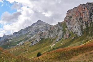 hermosa montaña paisaje con un rocoso cresta en el distancia y un otoño alpino prado en el primer plano foto