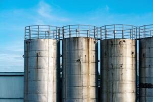 old metal industrial silo towers for bulk and liquid materials against the sky photo