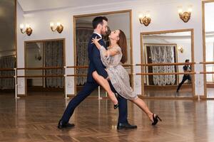 Pareja practicando bailando tango en un espacioso vacío salón foto