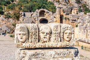 stone-cut faces - antique theater masks - in the ruins of the ancient city of Myra, Turkey photo