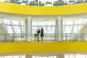 two teenage girls in the middle of the structures of a modern multi-storey mall photo