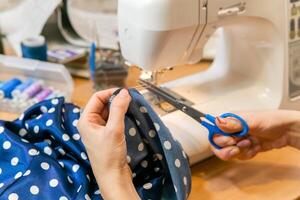 female hands while working on a sewing machine photo