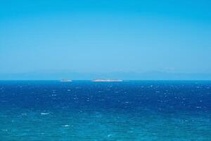 seascape on a windy sunny day with islands and distant barely visible shore on the horizon photo