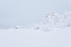 rocky plateau covered with deep snow under a winter sky photo