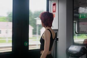 joven mujer es preparando a obtener apagado a un estación desde un suburbano tren coche foto