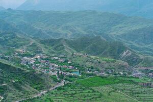 aéreo ver de un pueblo en un montaña Valle entre jardines y campos en daguestán foto