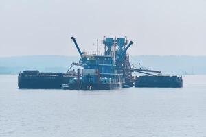 floating sand mining plant - dredger and separator - on the river photo