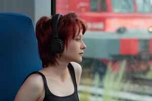 joven mujer escuchando a música mientras montando en un viajero diario al trabajo tren coche foto