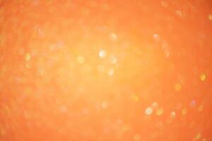 Sparkles defocus light. Glitter paper defocus as background. Orange background light and shadow. photo