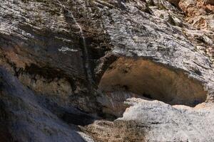 rock wall with streams of water flowing down it over the talus in the mountains photo