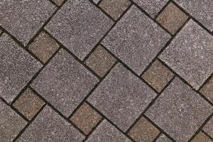 fragment of sidewalk from square tiles of different sizes photo