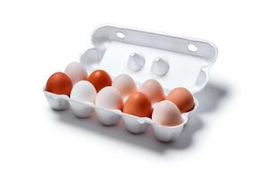 eggs of different colors from white to brown together in a crate, isolated on a white background photo