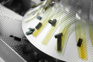 Close-up of a rotating detail of a packaging machine in a confectionery factory photo