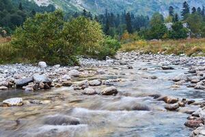 mountain river in autumn landscape, water blurred in motion photo