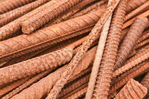 rusty reinforcing bars piled in a heap close-up photo