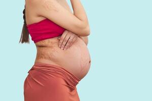 belly of pregnant woman isolated on light background photo