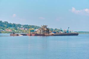 floating sand mining plant - dredger and separator - on the river photo