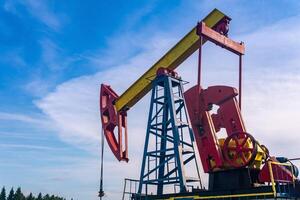 bomba extractora en un petróleo bien en contra el antecedentes de cielo foto