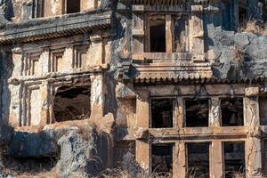 ruins of a rocky necropolis with tombs carved in stone in Myra Lycian photo