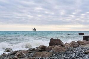 winter beach with seascape and a rickety structure on the stilts of an aquaculture farm in the distance photo