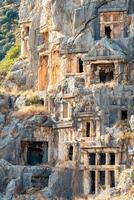 antiguo tallado en piedra tumba en el ladera de la montaña en myra licio demré, Turquía foto