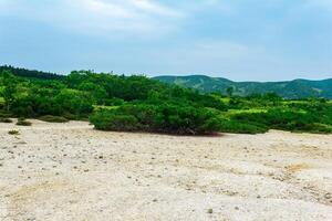 landscape of Kunashir island, tephra beach of a hot lake at the bottom of Golovnin volcano caldera photo