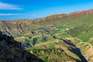 mountain landscape with a village on a slope under a huge rocky ridge, Chokh in Dagestan photo