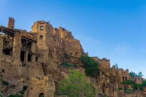 ruined old high stone houses in the abandoned village of Gamsutl, Dagestan photo