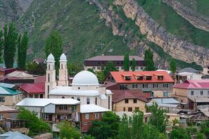 mountain village with a mosque in a valley under rock wall, Gunib town in Dagestan photo