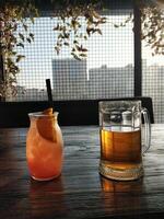 Drinks in orange colors standing on a wooden table photo