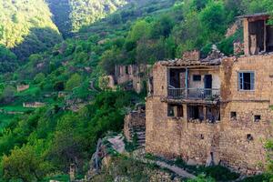 abandoned houses on a mountainside in the ghost village of Gamsutl in Dagestan photo