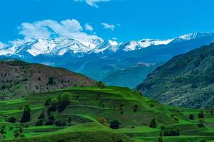paisaje de montañoso daguestán con aterrazado campos y Nevado picos en el distancia foto