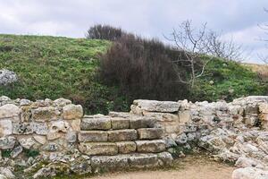 steps in the ruins of an antique house lead to an unexcavated part of it under the hill photo