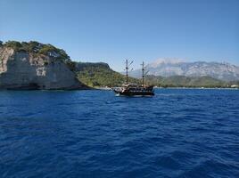 Blue sea and mountains, a ship is sailing on the horizon photo