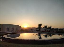 We meet the sunrise near a quiet fountain and palm trees in Egypt photo