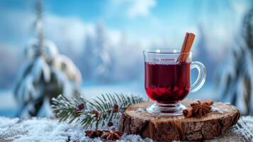 AI generated A glass of mulled red wine with cinnamon on old rustic wooden plank against blue background with winter landscape photo