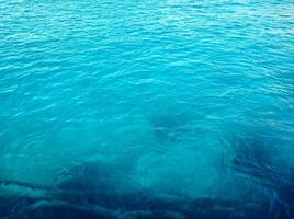 hermosa Rico azul textura de el mar con pequeño olas foto