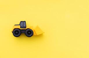 Wheel loader miniature isolated on yellow background. After some edits. photo