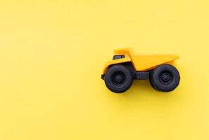 A dump truck miniature isolated on yellow background. After some edits. photo
