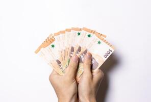 Hand holding amount of money isolated on white background. After some edits. photo