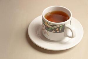 A cup of herbal tea on its saucer. After some edits. photo