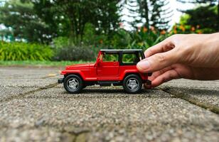 concepto para al aire libre ocupaciones con juguete para niños. foto de un juguete coche retenida por mano, después algunos ediciones