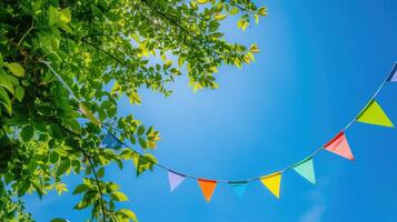 ai generado vistoso banderín cuerda decoración en verde árbol follaje en azul cielo, verano fiesta antecedentes modelo bandera con Copiar espacio foto