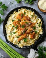 ai generado crujiente pollo Fettuccine Alfredo en el negro cacerola, allí son apio hojas y paño alrededor el pan foto