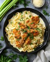 ai generado crujiente pollo Fettuccine Alfredo en el negro cacerola, allí son apio hojas y paño alrededor el pan foto