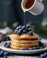 AI generated Gluten free vegan blueberry pancakes, blueberries on top of pancakes and around, The cup is watering the pancakes from above photo